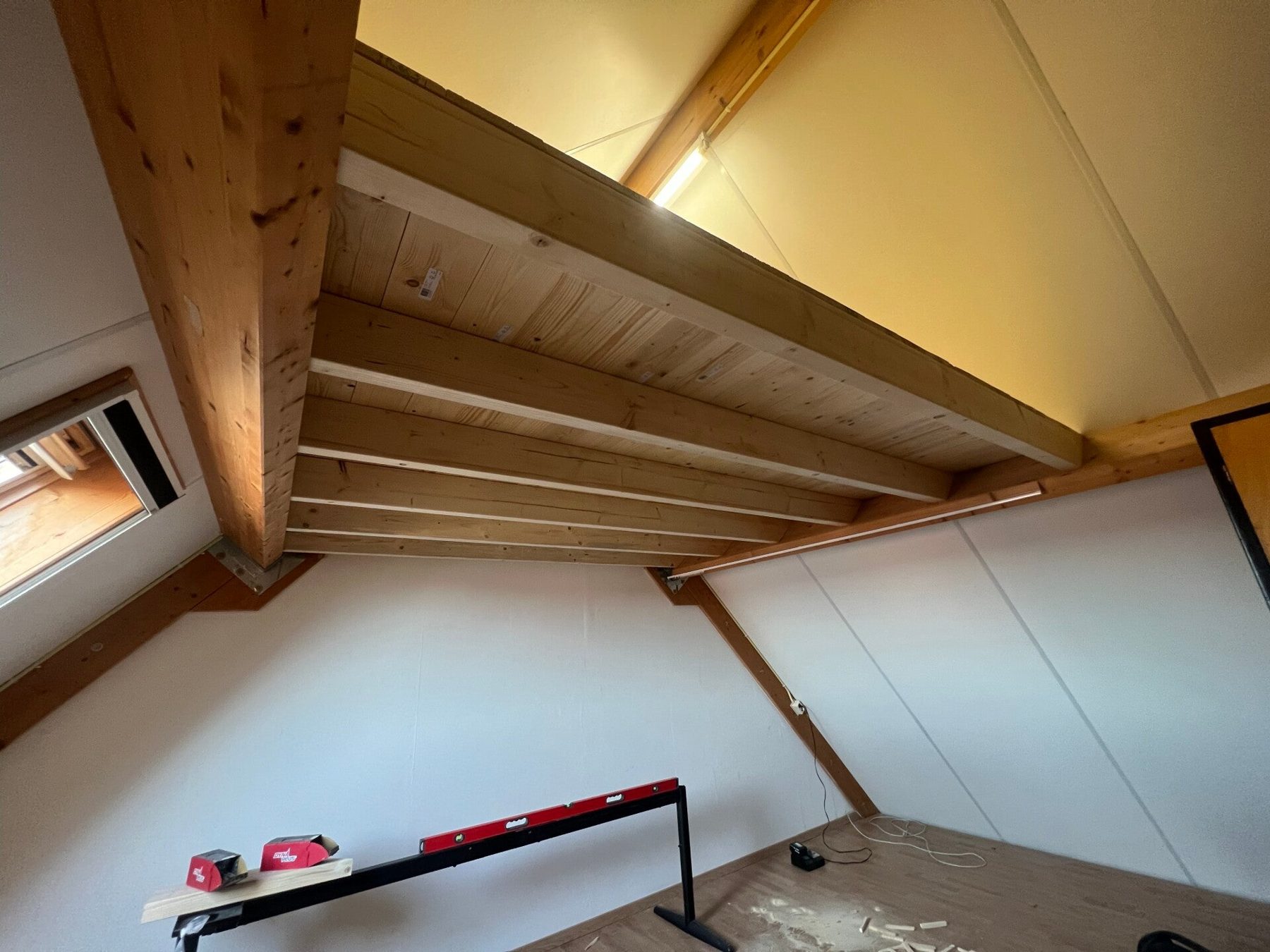 Zolder in renovatie met nieuwe houten balken en dakbeschot